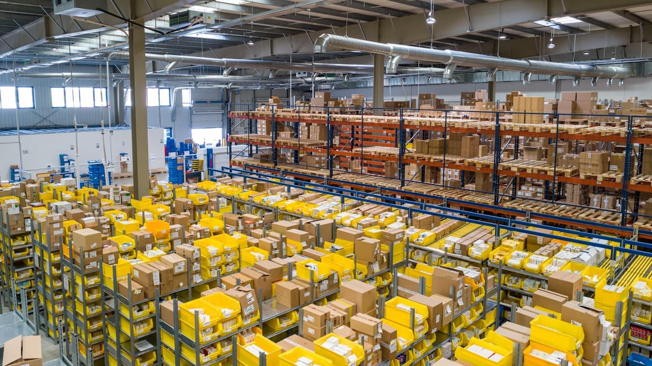 Large fulfillment warehouse with shelves and stacks of packed shipping boxes ready for delivery