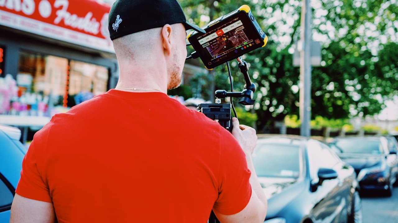 Person filming a live video on a phone gimbal outside a retail storefront