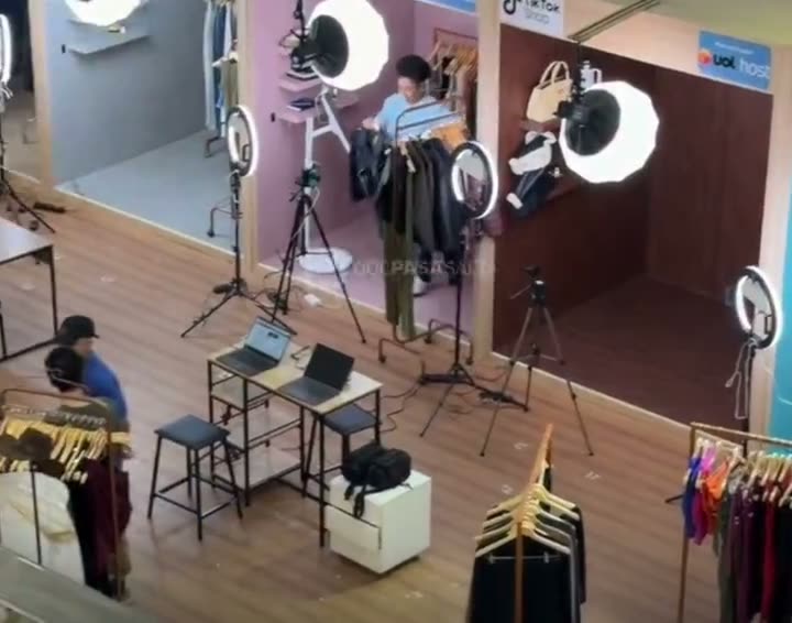 Live shopping studio with ring lights, clothing racks and laptops