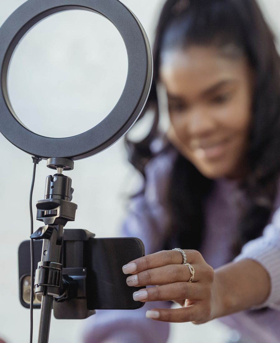 Host adjusting a phone on a ring light before going live
